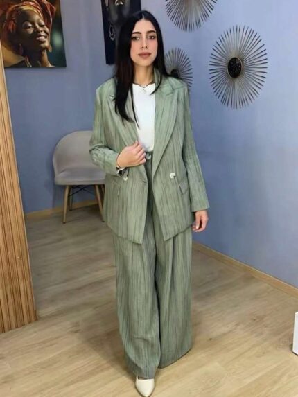 Femme portant un ensemble tailleur plissé vert sauge élégant avec pantalon large et veste assortie
