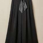 Pantalon palazzo noir fluide avec texture et ceinture foulard élégante