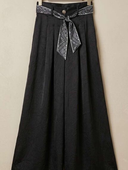 Pantalon palazzo noir fluide avec texture et ceinture foulard élégante