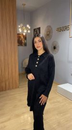 L'Indispensable Noir en Deux Pièces Revisitez les classiques avec notre superbe ensemble noir deux pièces, une tenue qui incarne la sobriété élégante par excellence. Le noir, couleur intemporelle de la sophistication, vous assure une silhouette affinée et une prestance impeccable en toute circonstance. Conçu pour la femme marocaine à la recherche d'un vêtement à la fois pudique, moderne et extrêmement polyvalent, cet ensemble est idéal pour vos journées de travail, vos sorties citadines ou vos moments de détente à Nador. Un Design Structuré et un Confort Absolu Cet ensemble complet se distingue par sa fluidité et ses détails contrastants qui apportent une touche de lumière à la tenue : Tunique Longue Boutonnée : Le haut de cet ensemble noir deux pièces est une tunique ample à manches longues dotée d'un col classique. Elle se démarque par sa boutonnière partielle à l'avant, ornée de gros boutons nacrés ou métalliques qui structurent visuellement la pièce et lui donnent un cachet "couture". Pantalon Large Assorti : Le bas complète parfaitement la tenue avec une coupe droite et très ample (wide leg). Fluide et léger, il accompagne vos mouvements avec grâce tout en garantissant une couvrance totale et un confort optimal. Matière Douce et Qualitative : Confectionné dans un tissu souple au tombé impeccable, cet ensemble offre une sensation de douceur sur la peau et une allure soignée qui ne se froisse pas facilement. Comment porter votre Ensemble Noir Deux Pièces ? La force de cet ensemble noir deux pièces est sa capacité à s'adapter à toutes vos envies de stylisme. Pour un look de jour urbain et dynamique, associez-le à une paire de baskets blanches (comme sur la vidéo) pour faire écho à la clarté des boutons. Pour une allure plus sophistiquée de type "Working Girl", optez pour des mocassins en cuir ou des bottines à talons. Vous pouvez également multiplier vos looks en séparant les pièces : portez la tunique longue avec un jean bleu classique pour un style décontracté, ou associez le pantalon noir large à un chemisier coloré pour un contraste élégant !