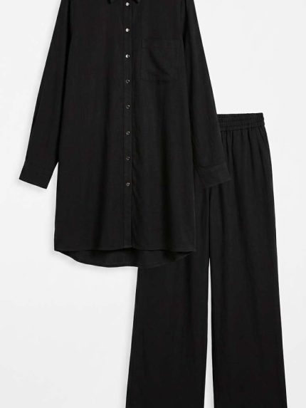 Ensemble femme deux pièces composé d'une chemise longue et d'un pantalon large noir, style chic et décontracté.