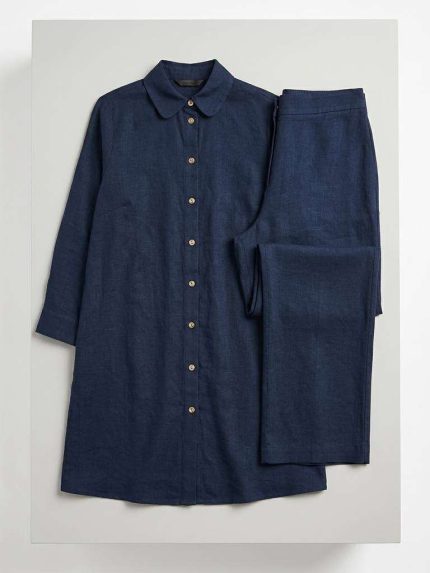 Ensemble deux pièces pour femme composé d'une chemise en lin bleu nuit et d'un pantalon assorti sur fond neutre.