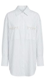 Chemise blanche à rayures verticales avec poches ornées de perles pour femme, style élégant et moderne.