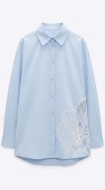 Chemise bleu ciel pour femme avec détails en broderie florale blanche sur le côté