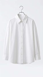 Chemise blanche classique pour femme avec coupe oversize, présentée sur un cintre, style minimaliste et élégant.