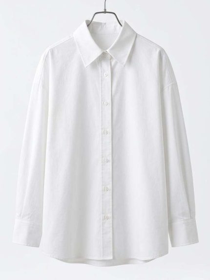 Chemise blanche classique pour femme avec coupe oversize, présentée sur un cintre, style minimaliste et élégant.