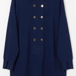 Pull-over en maille bleu marine avec boutons dorés et col polo porté par une femme