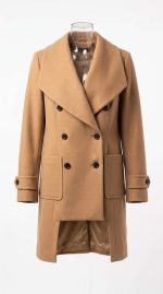 Manteau court en laine camel avec double boutonnage et coupe structurée porté sur un mannequin invisible