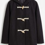 Manteau noir à capuche avec doublure en fourrure et attaches brandebourgs sur cintre