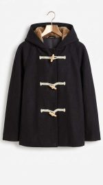 Manteau noir à capuche avec doublure en fourrure et attaches brandebourgs sur cintre