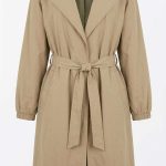 Trench long beige pour femme avec ceinture et col à revers sur fond blanc