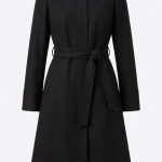 Manteau long noir élégant avec finitions en fourrure sur le col, marque Orkidia Fashion.