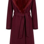 Manteau long bordeaux pour femme avec col en fausse fourrure et ceinture à la taille, style chic et hivernal.