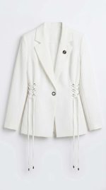 Blazer blanc chic pour femme avec laçage latéral sur un fond minimaliste blanc