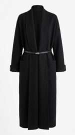 Manteau long noir en maille avec ceinture fine et poches plaquées, style minimaliste et élégant.