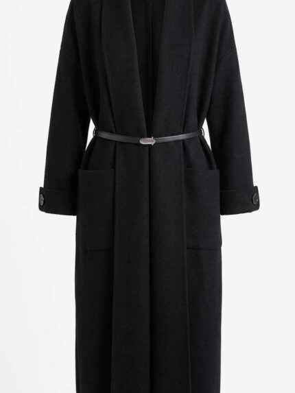 Manteau long noir en maille avec ceinture fine et poches plaquées, style minimaliste et élégant.