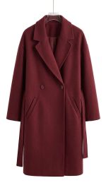 Manteau long femme bordeaux avec ceinture à la taille présenté sur un cintre