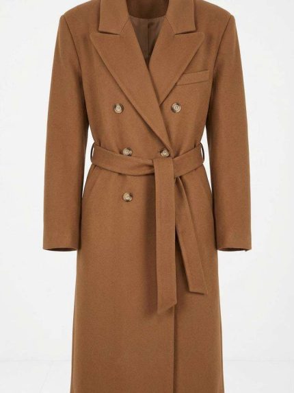 Manteau long camel pour femme avec ceinture et double boutonnage sur fond clair