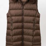 Gilet long matelassé marron chocolat avec capuche en fausse fourrure, vue de face sur cintre, collection Orkidia Fashion.