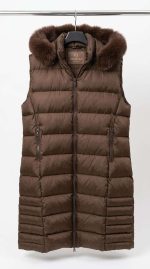 Gilet long matelassé marron chocolat avec capuche en fausse fourrure, vue de face sur cintre, collection Orkidia Fashion.