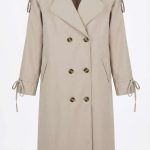 Trench-coat beige pour femme avec boutons et liens aux manches, style chic et classique pour la mi-saison chez Orkidia Fashion.