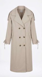 Trench-coat beige pour femme avec boutons et liens aux manches, style chic et classique pour la mi-saison chez Orkidia Fashion.