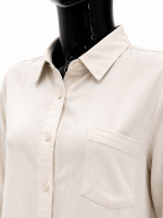 Ensemble femme beige écru composé d’une chemise longue boutonnée et d’un pantalon large.
